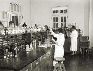 Black and white image of people in lab coats working in a chemistry lab